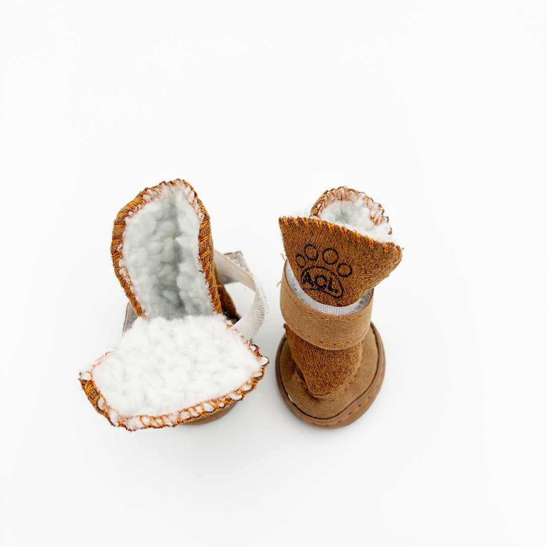 Pair of brown pet boots with white fur lining on a white background