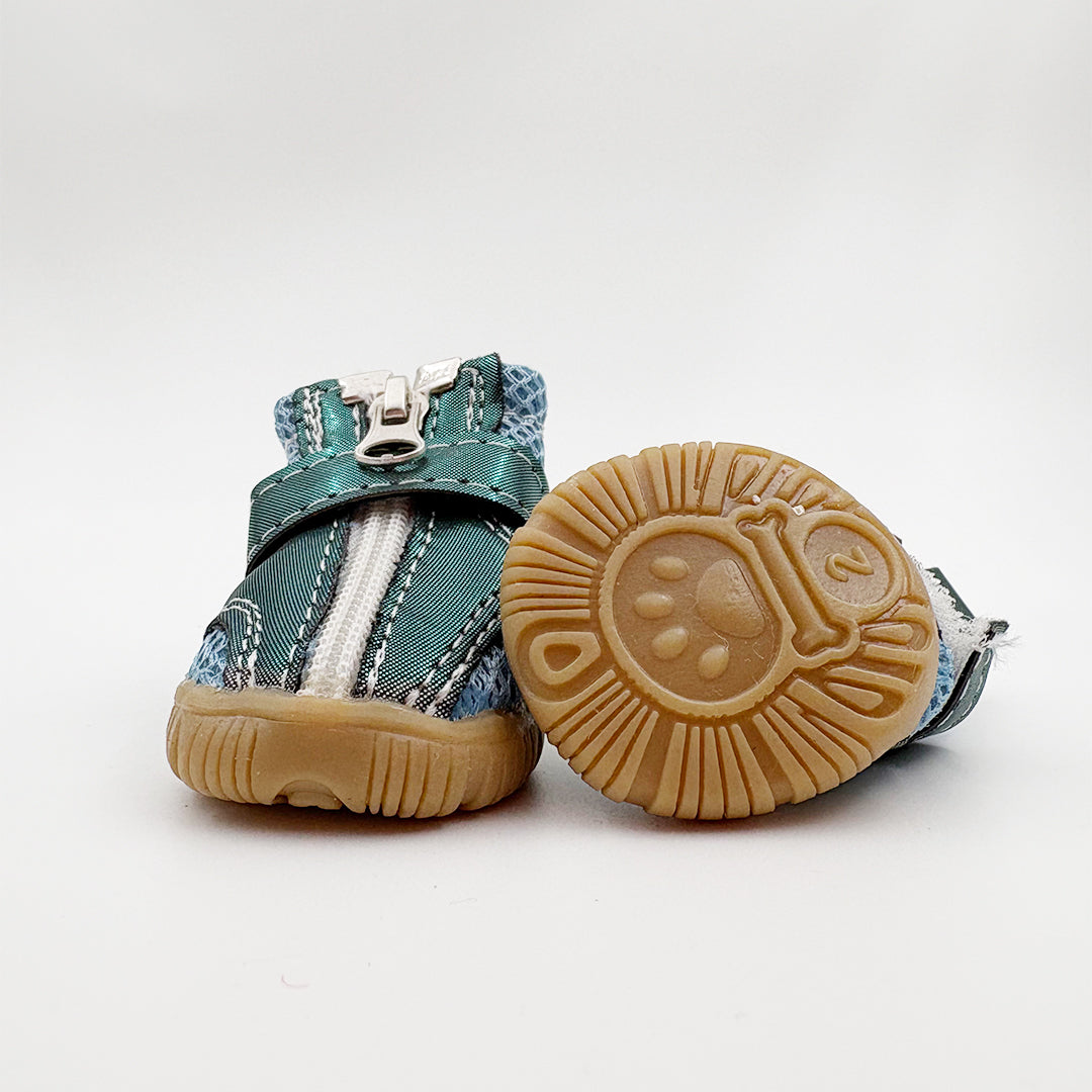 Pair of 4 teal baby dog shoes with brown soles on a white background