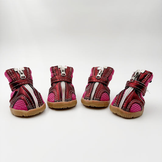 Four pairs of red and pink pet boots on a white background