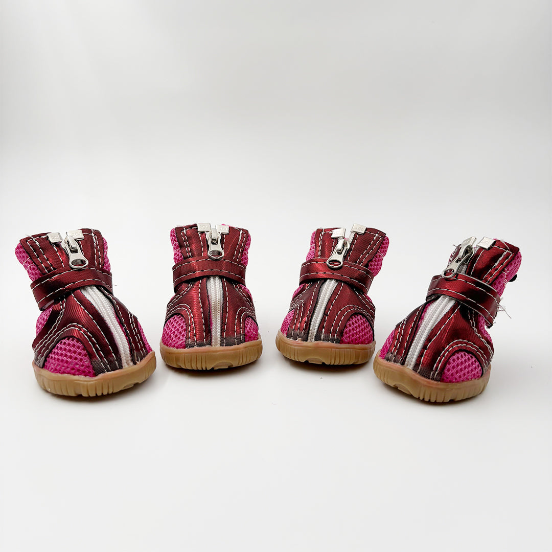 Four pairs of red and pink pet boots on a white background